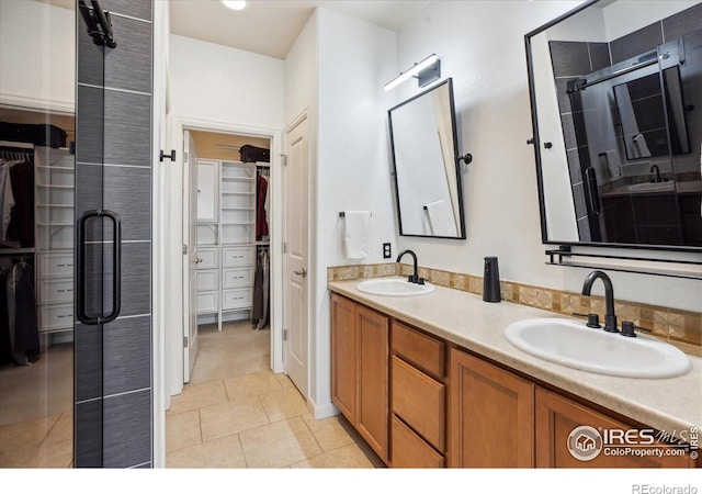 16031 W 63rd Ln W Unit D, Arvada, CO 80403 - full bathroom with a spacious closet, double vanity, a shower stall, and tile patterned floors