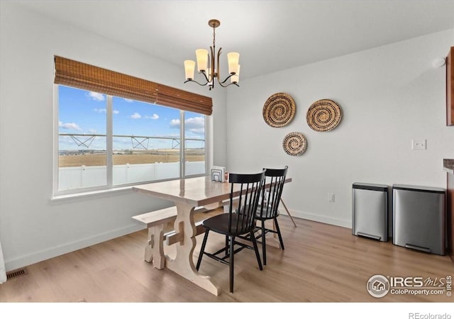 1718 101st Avenue Ct, Greeley, CO 80634 - dining space with a chandelier, light wood-style floors, and baseboards