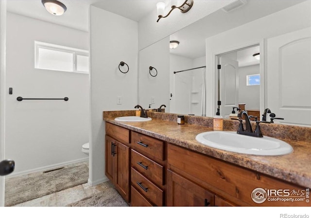 1718 101st Avenue Ct, Greeley, CO 80634 - full bathroom featuring double vanity, toilet, and a shower