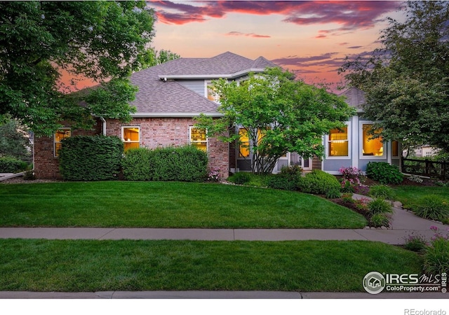 2133 Indian Peaks Cir, Longmont, CO 80504 - view of front of home with a lawn, roof with shingles, and brick siding