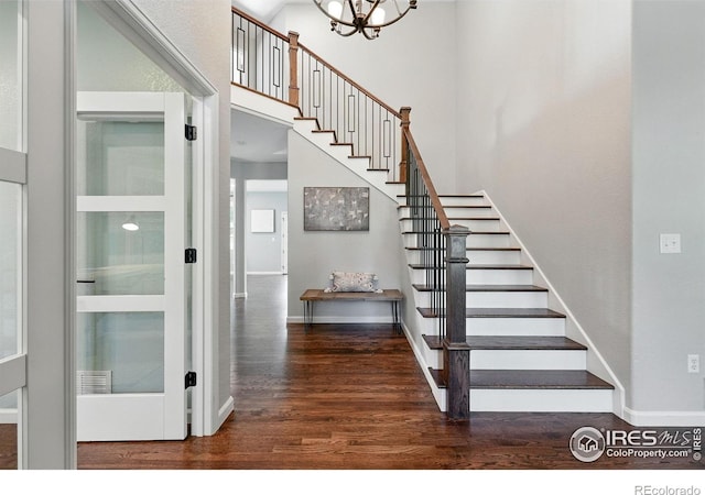 2133 Indian Peaks Cir, Longmont, CO 80504 - stairway featuring wood finished floors, a chandelier, and a high ceiling