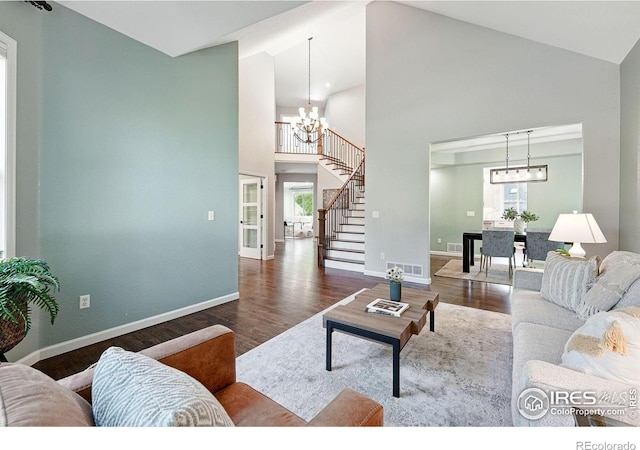 2133 Indian Peaks Cir, Longmont, CO 80504 - living area featuring wood finished floors, high vaulted ceiling, a chandelier, and stairway