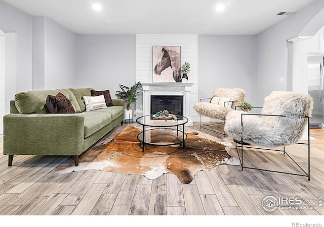 9139 County Road 54, Milliken, CO 80543 - living area with light wood-type flooring, recessed lighting, and a glass covered fireplace