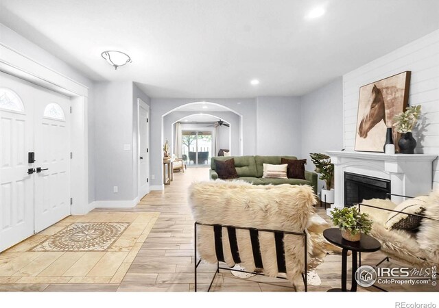 9139 County Road 54, Milliken, CO 80543 - living room featuring arched walkways, light wood finished floors, recessed lighting, a fireplace, and baseboards