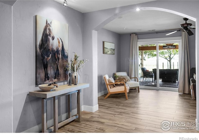 9139 County Road 54, Milliken, CO 80543 - living area with arched walkways, wood finished floors, ceiling fan, and baseboards