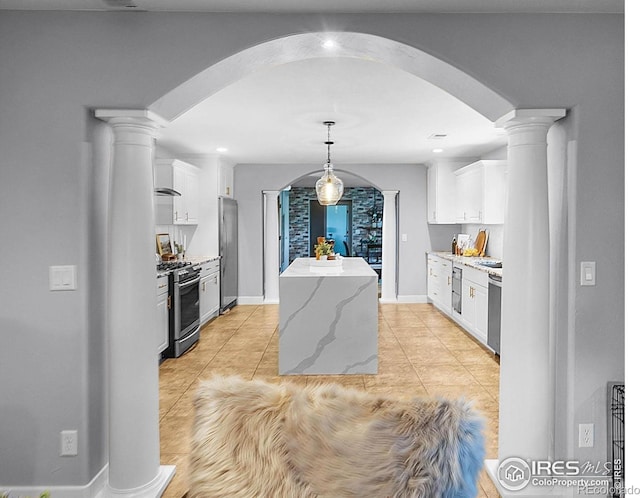 9139 County Road 54, Milliken, CO 80543 - kitchen featuring arched walkways, appliances with stainless steel finishes, a kitchen island, decorative columns, and recessed lighting