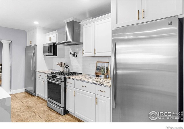 9139 County Road 54, Milliken, CO 80543 - kitchen with appliances with stainless steel finishes, wall chimney exhaust hood, decorative backsplash, white cabinetry, and light stone counters