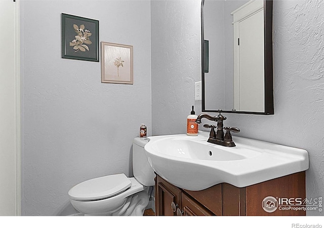 9139 County Road 54, Milliken, CO 80543 - half bath with vanity, a textured wall, and toilet