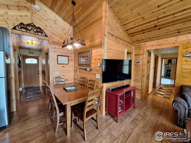 56 Pamlico Ct, Red Feather Lakes, CO 80545 - dining room featuring wooden walls, lofted ceiling, hardwood / wood-style flooring, and wooden ceiling