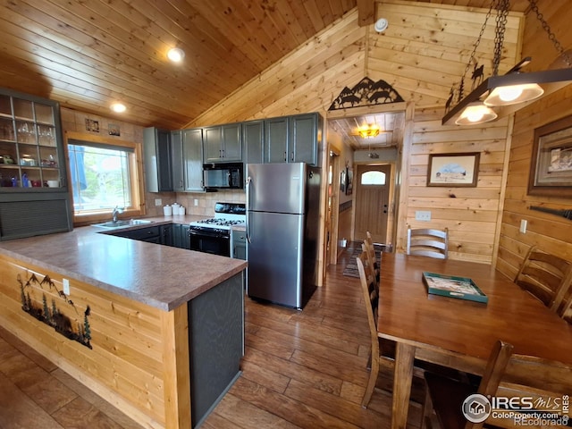 56 Pamlico Ct, Red Feather Lakes, CO 80545 - kitchen with freestanding refrigerator, black microwave, white gas range oven, vaulted ceiling, and wooden ceiling