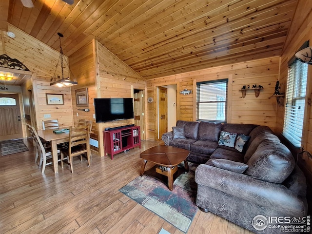 56 Pamlico Ct, Red Feather Lakes, CO 80545 - living room with wooden walls, lofted ceiling, plenty of natural light, and hardwood / wood-style flooring