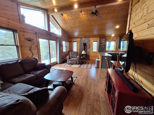 56 Pamlico Ct, Red Feather Lakes, CO 80545 - living area featuring wood walls, wood ceiling, healthy amount of natural light, light wood-type flooring, and a ceiling fan