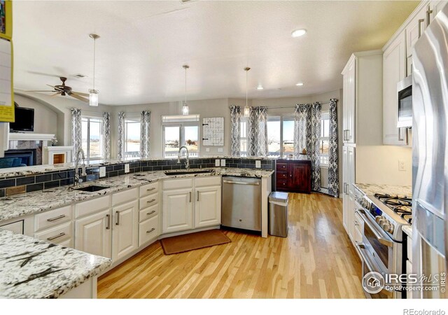 5895 E Conservation Dr, Frederick, CO 80504 - kitchen with appliances with stainless steel finishes, a sink, light wood-type flooring, plenty of natural light, and recessed lighting