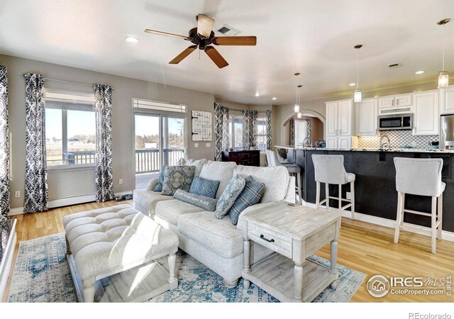 5895 E Conservation Dr, Frederick, CO 80504 - living room with ceiling fan, light wood finished floors, recessed lighting, baseboards, and baseboard heating