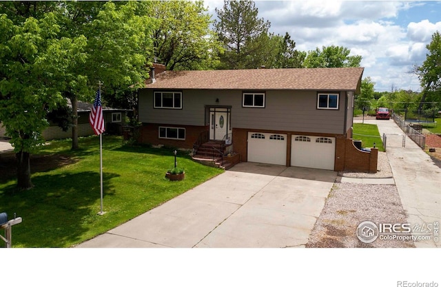 204 35th St SW, Loveland, CO 80537 - split foyer home with an attached garage, concrete driveway, and view of scattered trees