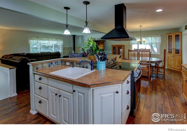 204 35th St SW, Loveland, CO 80537 - kitchen with wall chimney range hood, open floor plan, a sink, stainless steel electric range oven, and a wood stove