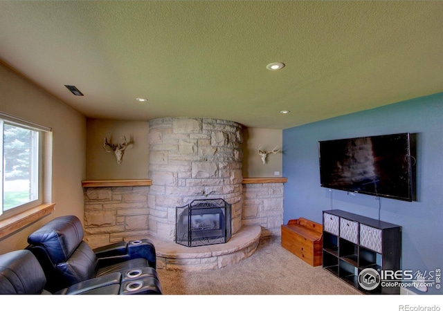 204 35th St SW, Loveland, CO 80537 - carpeted living area featuring a stone fireplace, a textured ceiling, and recessed lighting