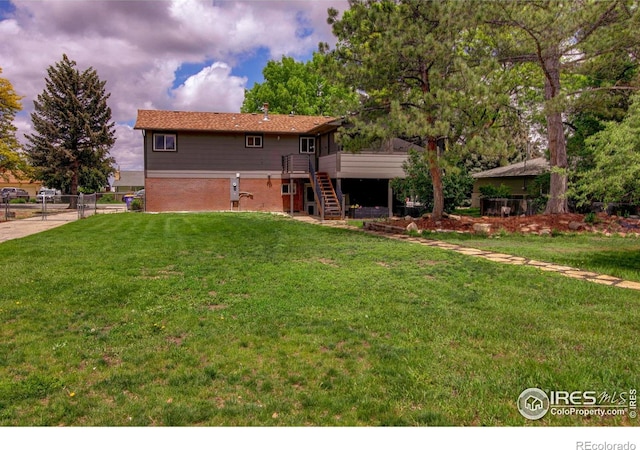 204 35th St SW, Loveland, CO 80537 - rear view of house with stairway, a wooden deck, brick siding, and a gate