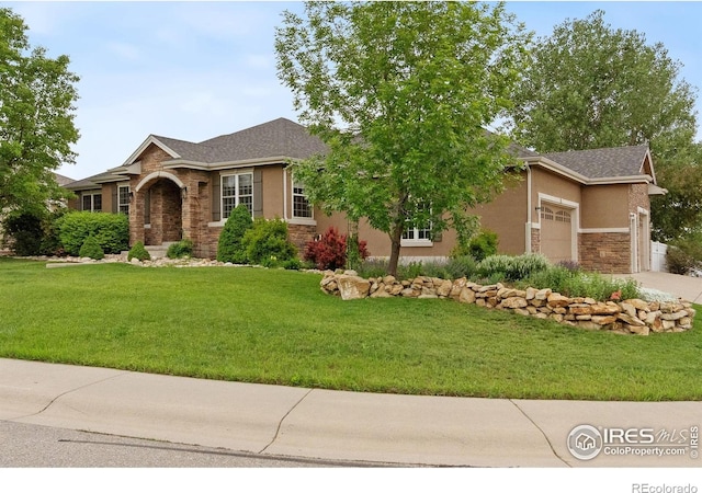 1926 Crested Butte Ct, Loveland, CO 80538 - view of front of property with stone siding, an attached garage, a front lawn, driveway, and stucco siding