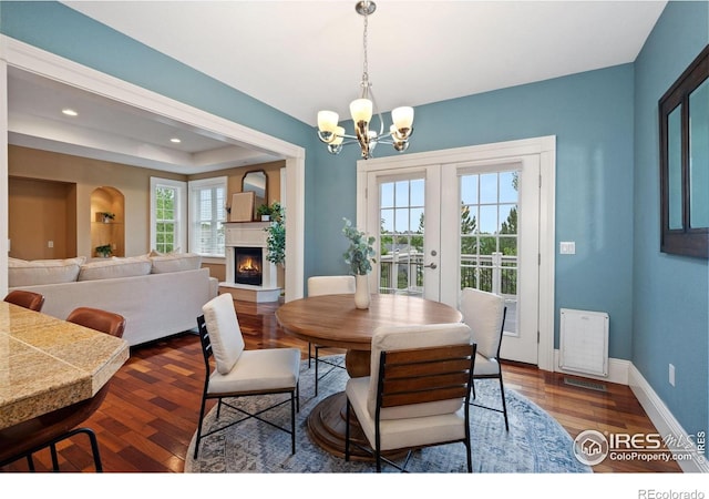 1926 Crested Butte Ct, Loveland, CO 80538 - dining area with a chandelier, a warm lit fireplace, dark wood finished floors, recessed lighting, and baseboards