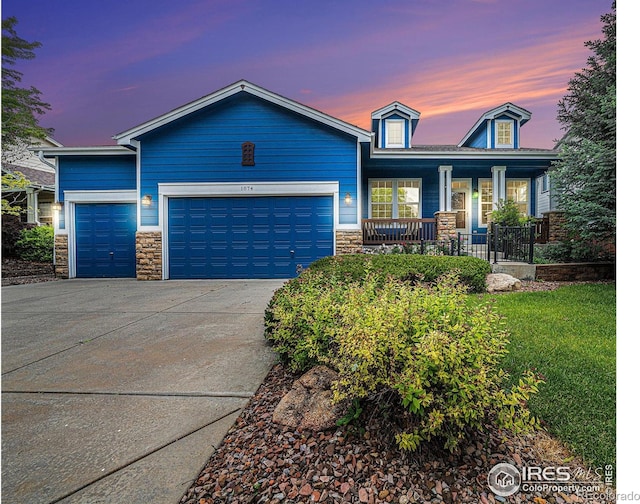 1874 Ute Creek Dr, Longmont, CO 80504 - single story home featuring covered porch, stone siding, concrete driveway, and an attached garage