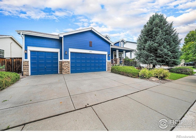 1874 Ute Creek Dr, Longmont, CO 80504 - view of front of home featuring stone siding, an attached garage, and driveway