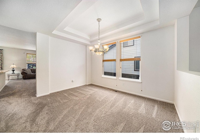 1874 Ute Creek Dr, Longmont, CO 80504 - carpeted empty room featuring a chandelier, a raised ceiling, and baseboards