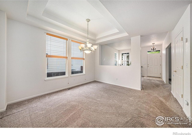 1874 Ute Creek Dr, Longmont, CO 80504 - carpeted empty room featuring a chandelier, a raised ceiling, and baseboards