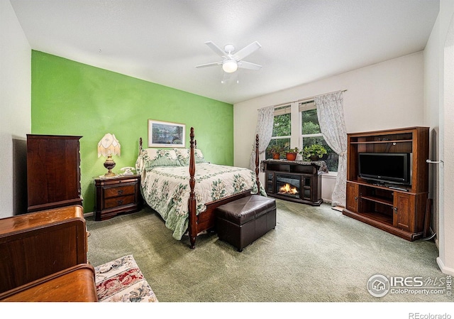 1874 Ute Creek Dr, Longmont, CO 80504 - carpeted bedroom featuring a ceiling fan, a lit fireplace, and baseboards