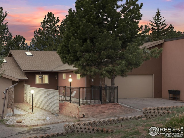 838 Vista Ln, Estes Park, CO 80517 - view of front of home featuring concrete driveway, stucco siding, a garage, and roof with shingles