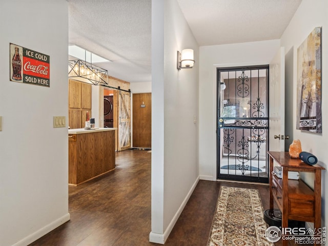 838 Vista Ln, Estes Park, CO 80517 - entrance foyer with a barn door, stacked washer / drying machine, baseboards, and a textured ceiling