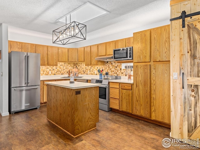 838 Vista Ln, Estes Park, CO 80517 - kitchen with stainless steel appliances, under cabinet range hood, a textured ceiling, light countertops, and decorative backsplash