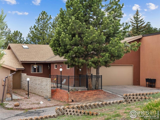 838 Vista Ln, Estes Park, CO 80517 - view of front of house with asphalt driveway, a garage, stucco siding, and roof with shingles