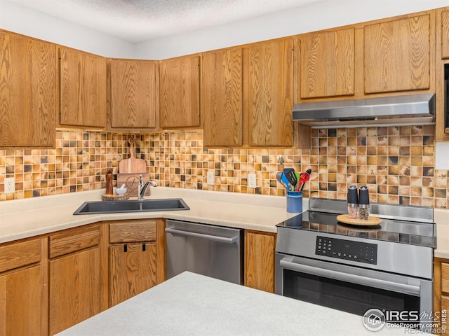 838 Vista Ln, Estes Park, CO 80517 - kitchen with appliances with stainless steel finishes, under cabinet range hood, light countertops, a sink, and a textured ceiling