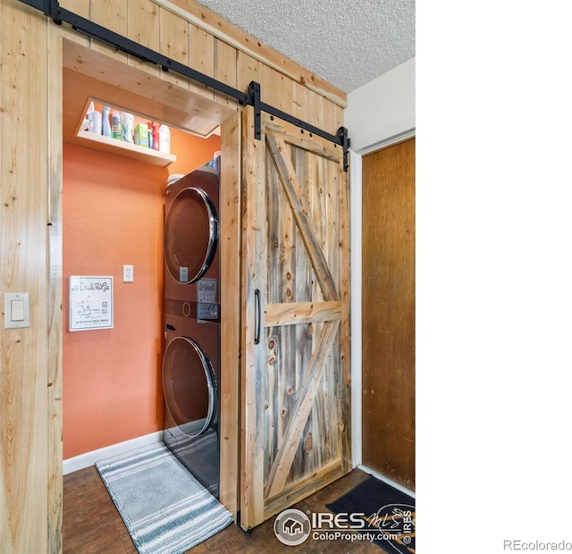 838 Vista Ln, Estes Park, CO 80517 - detailed view of stacked washer and clothes dryer, a barn door, and a textured ceiling