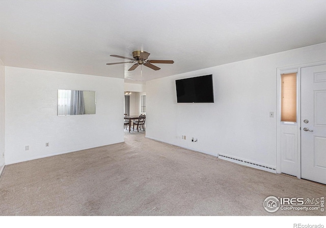 213 S 4th St, La Salle, CO 80645 - unfurnished living room featuring baseboard heating, carpet floors, a ceiling fan, and baseboards