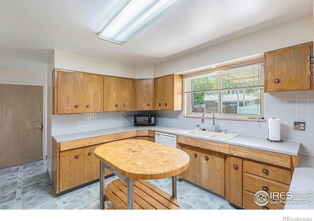 213 S 4th St, La Salle, CO 80645 - kitchen featuring a sink, brown cabinets, light countertops, and tasteful backsplash