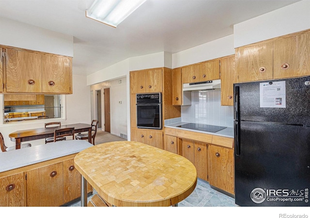 213 S 4th St, La Salle, CO 80645 - kitchen featuring black appliances, under cabinet range hood, light countertops, decorative backsplash, and brown cabinetry