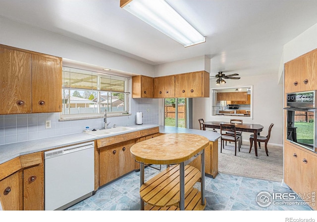 213 S 4th St, La Salle, CO 80645 - kitchen featuring dishwasher, a sink, black oven, and brown cabinets