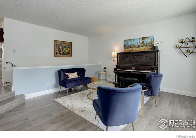 112 Dawson Pl, Longmont, CO 80504 - living room with wood finished floors, a textured ceiling, baseboards, and stairs
