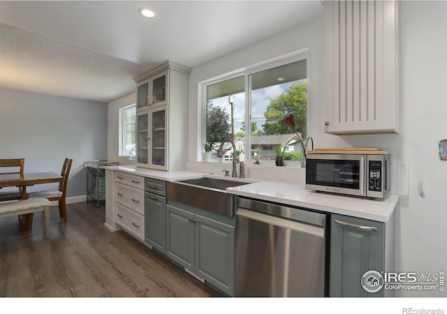 112 Dawson Pl, Longmont, CO 80504 - kitchen featuring stainless steel appliances, gray cabinets, a sink, glass insert cabinets, and dark wood-style floors