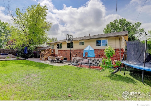 112 Dawson Pl, Longmont, CO 80504 - back of house featuring a trampoline, a patio, and brick siding