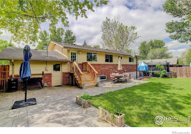 112 Dawson Pl, Longmont, CO 80504 - back of house with brick siding, a trampoline, and a patio area
