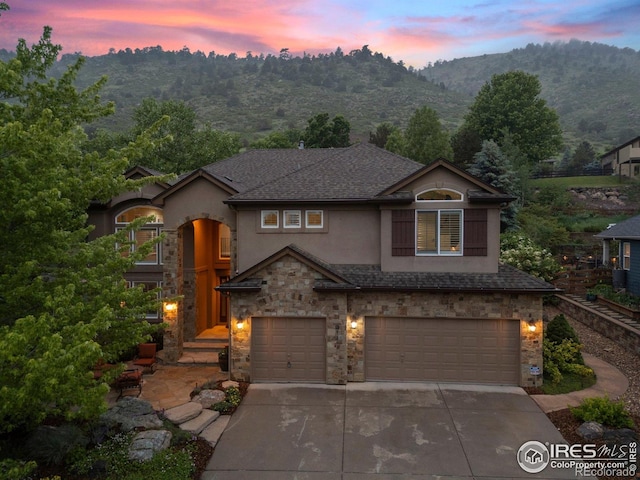 19061 Eagle Ridge Dr, Golden, CO 80401 - traditional-style house featuring stone siding, an attached garage, driveway, and stucco siding