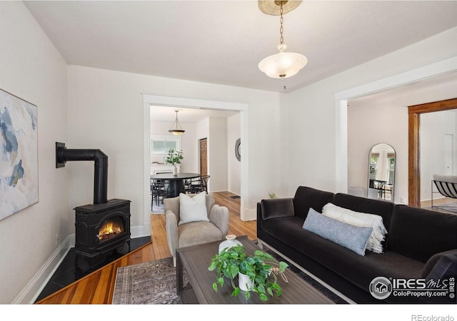 729 Peterson St, Fort Collins, CO 80524 - living room with wood finished floors, a wood stove, and baseboards