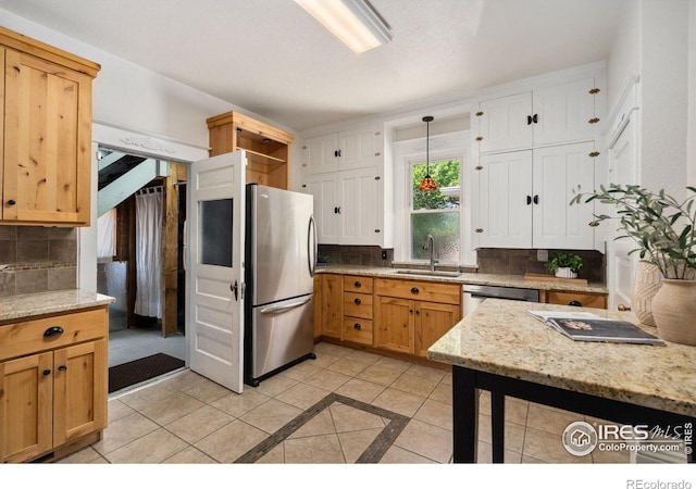 729 Peterson St, Fort Collins, CO 80524 - kitchen featuring appliances with stainless steel finishes, a sink, backsplash, and light stone countertops