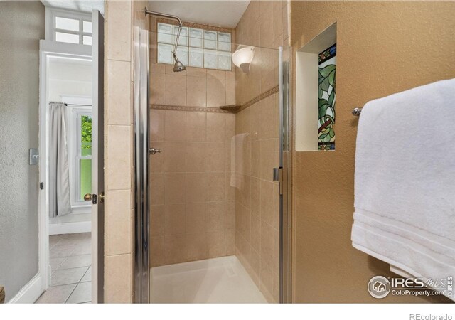 729 Peterson St, Fort Collins, CO 80524 - full bath with a shower stall, tile patterned floors, plenty of natural light, a textured wall, and baseboards