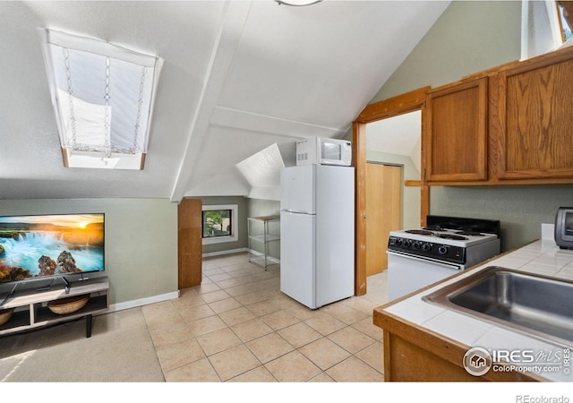 729 Peterson St, Fort Collins, CO 80524 - kitchen featuring white appliances, tile countertops, vaulted ceiling, brown cabinets, and light tile patterned floors