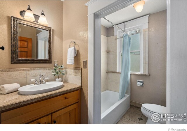 729 Peterson St, Fort Collins, CO 80524 - bathroom featuring shower / bath combo with shower curtain, toilet, tile patterned floors, vanity, and a textured wall