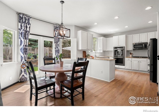 1682 Crestview Ln, Erie, CO 80516 - dining space featuring healthy amount of natural light, light wood finished floors, a chandelier, and recessed lighting